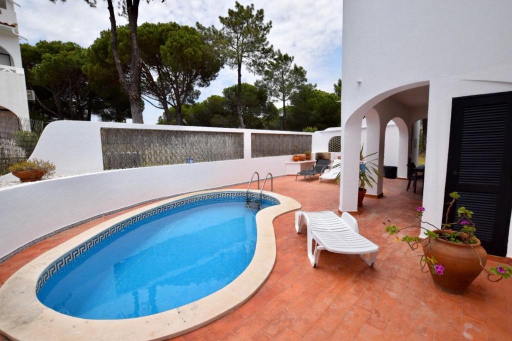 a swimming pool on a patio next to a house at Villa Oleander in Vale do Lobo