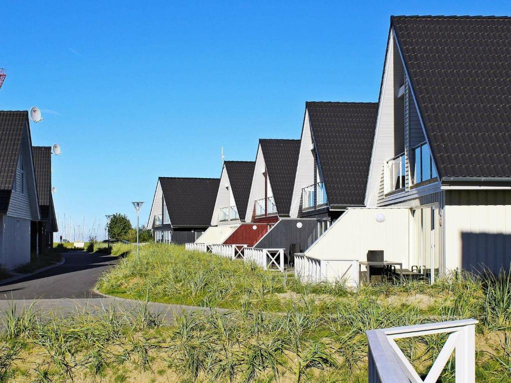 una fila de casas con techos negros en una calle en 4 person holiday home in Wendtorf en Wendtorf