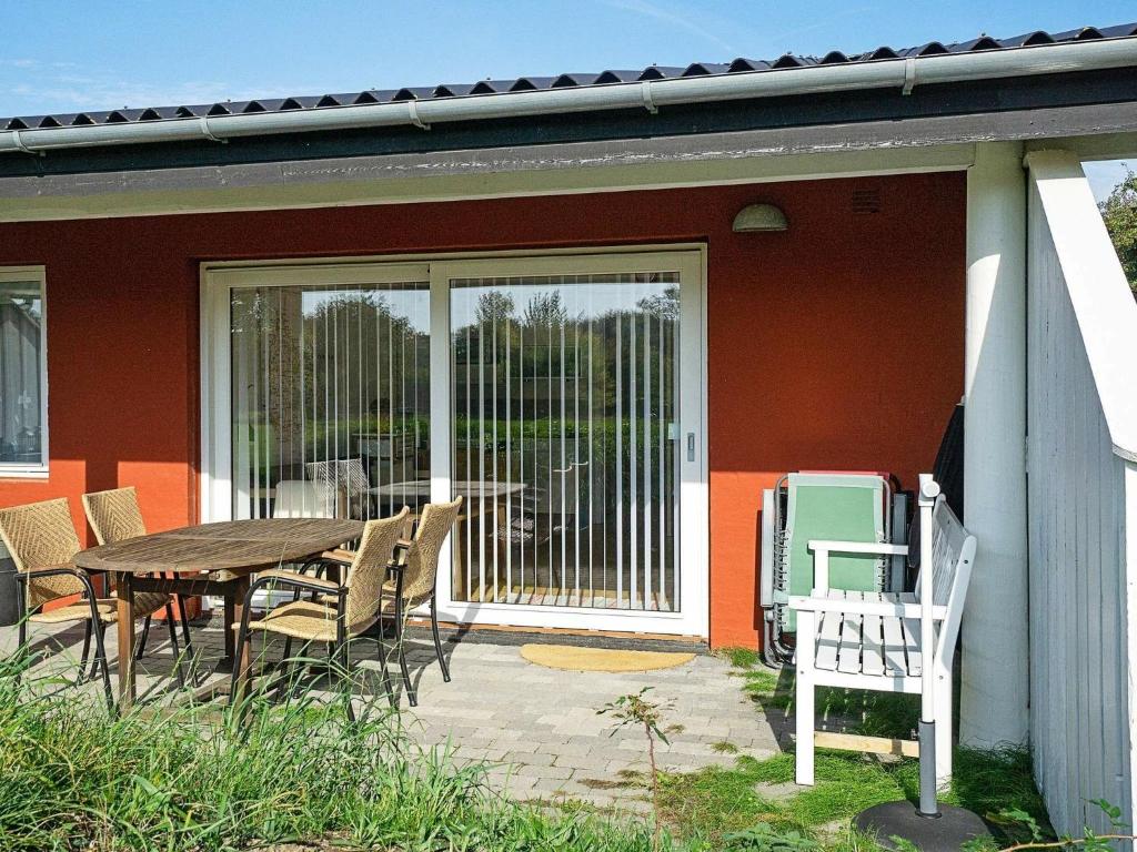 un patio con tavolo e sedie di fronte a una casa di Apartment Aakirkeby ad Åkirkeby