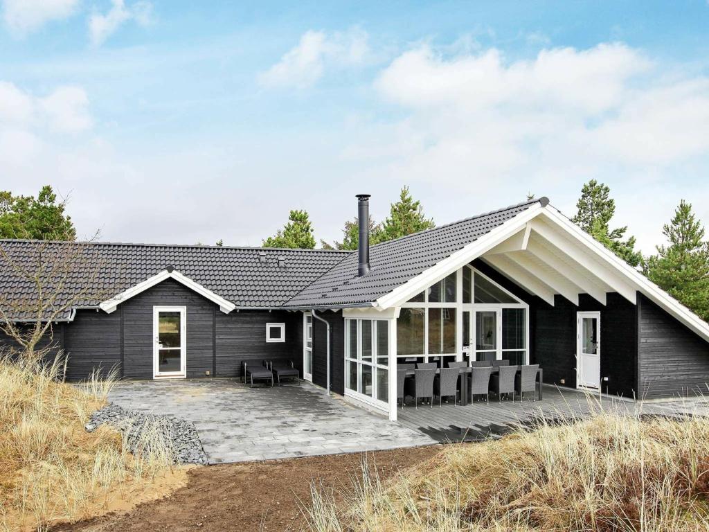 een zwart huis met een wit dak bij Holiday home Blåvand IX in Blåvand