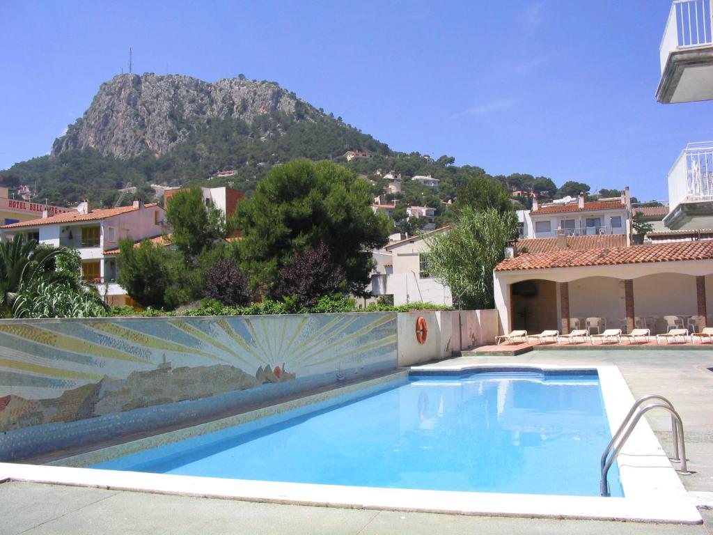 uma piscina numa villa com uma montanha ao fundo em Leo em L'Estartit