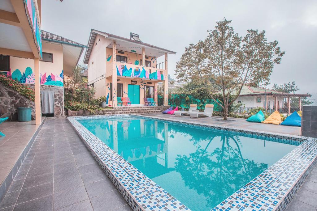 uma piscina em frente a uma casa em d'Oasis Mountain Resort em Puncak