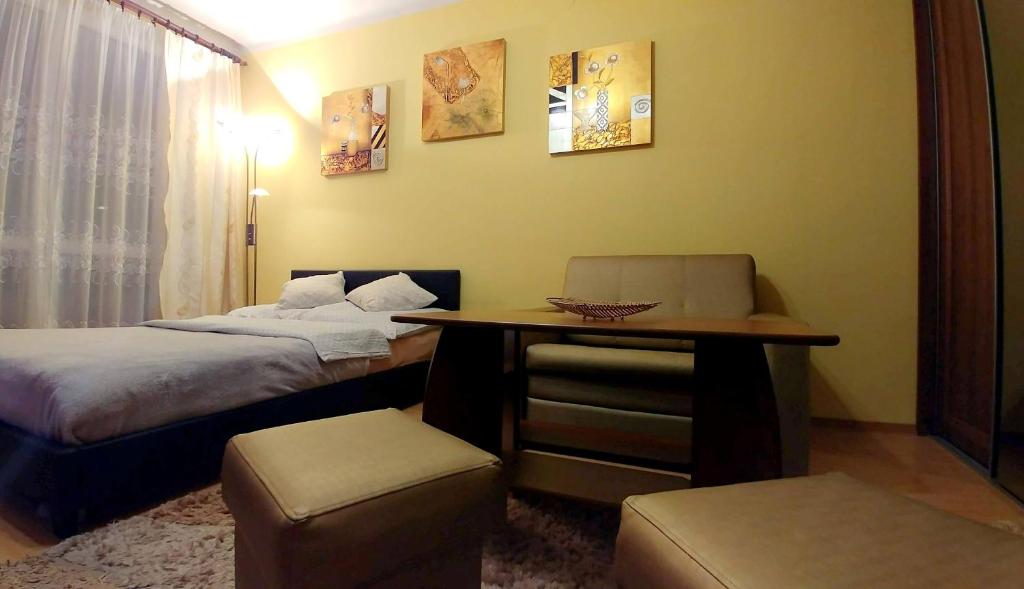 um quarto com duas camas, uma mesa e uma cadeira em Apartament TwojaNoc em Mielec