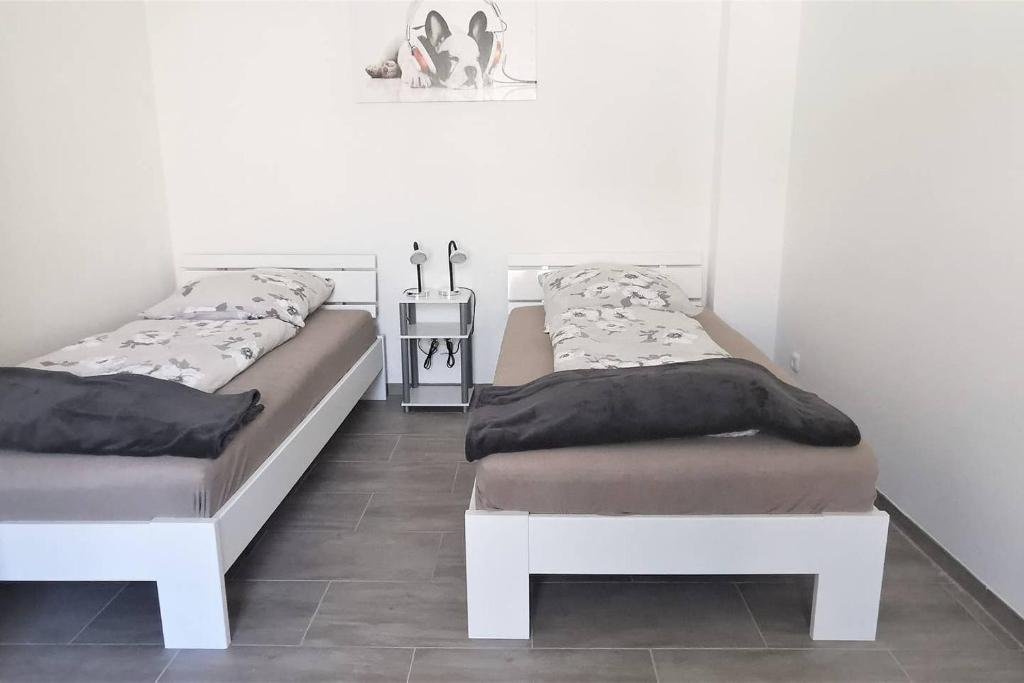 two beds are sitting in a room with a tile floor at Apartment außen Pfui innen Hui in Mönchengladbach