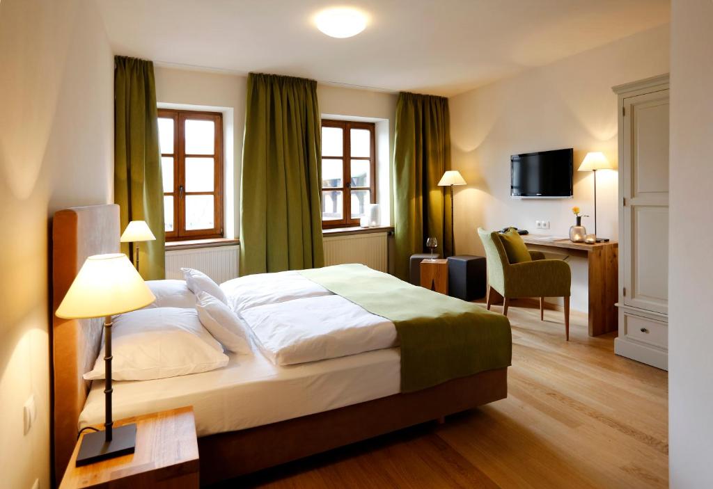 ein Hotelzimmer mit einem Bett und einem Schreibtisch in der Unterkunft Weinkastell Zum Weissen Ross in Kallstadt