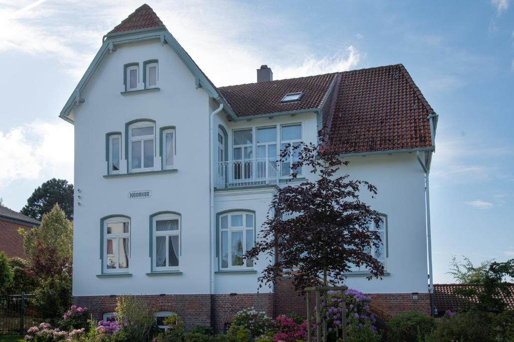 ein weißes Haus mit braunem Dach in der Unterkunft Villa Noorhus in Eckernförde