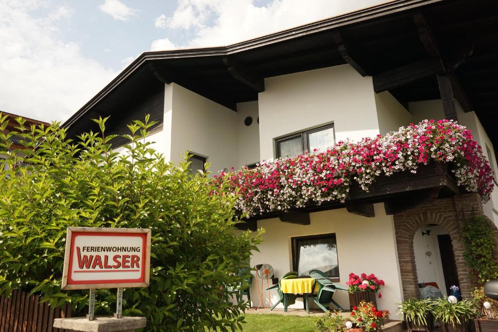 un panneau devant une maison fleurie dans l'établissement Haus Walser, à Tarrenz