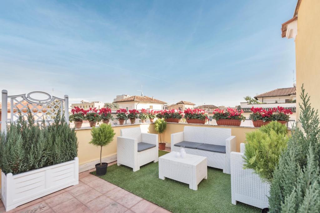 a rooftop patio with white furniture and plants at Hotel Infinito - Gruppo BLAM HOTELS in Rome
