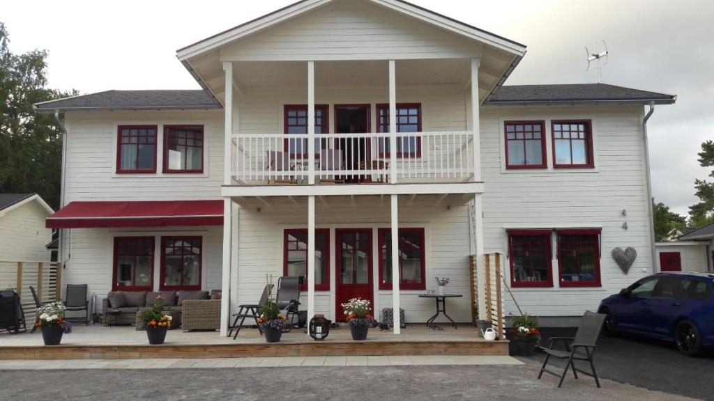 a white house with a porch and a balcony at Öregrund BnB in Öregrund