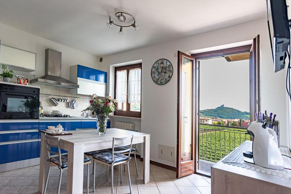 una cucina con tavolo bianco con sedie e finestra di La bella casa di Roberta a Illasi