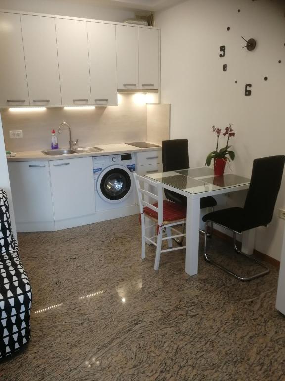 a kitchen with a table and a sink and a table at Apartma ROK in Ankaran