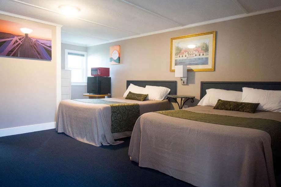 um quarto de hotel com duas camas e uma televisão em Sea Turn Motel em York