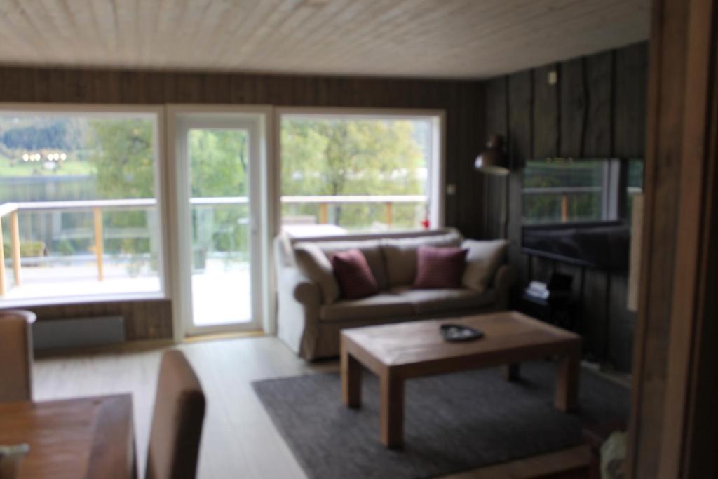uma sala de estar com um sofá e uma mesa em Oppheim-Myrkdalen privat hytte em Vossestrand
