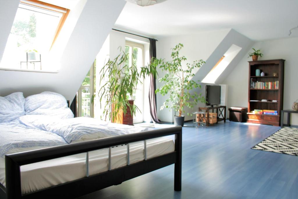 ein Schlafzimmer mit einem Bett und einigen Pflanzen in der Unterkunft Zentrale Ferienwohnung Anker im Sonnenblumenhaus in Flensburg