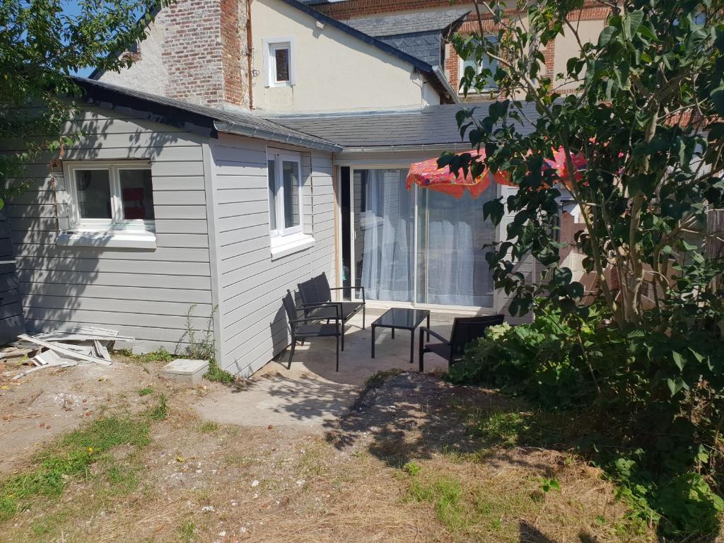 une terrasse avec deux chaises et une table en face d'une maison dans l'établissement Le verger d'Honfleur, à Honfleur