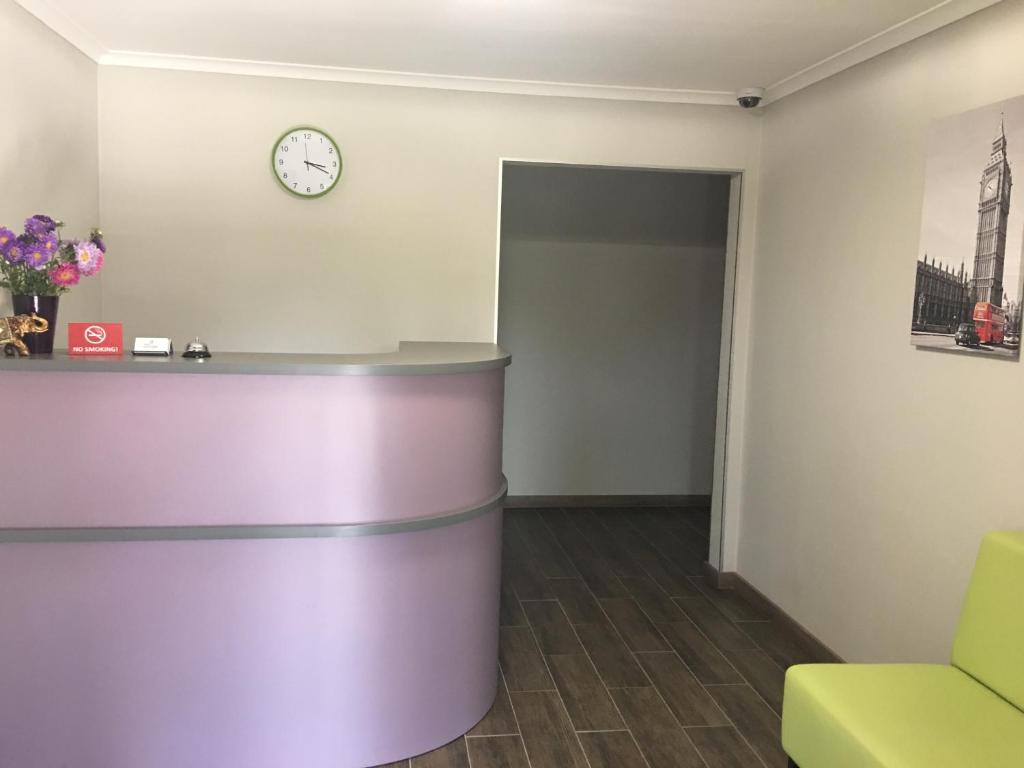 uma sala de espera com um relógio na parede em 7Days em Hadyach