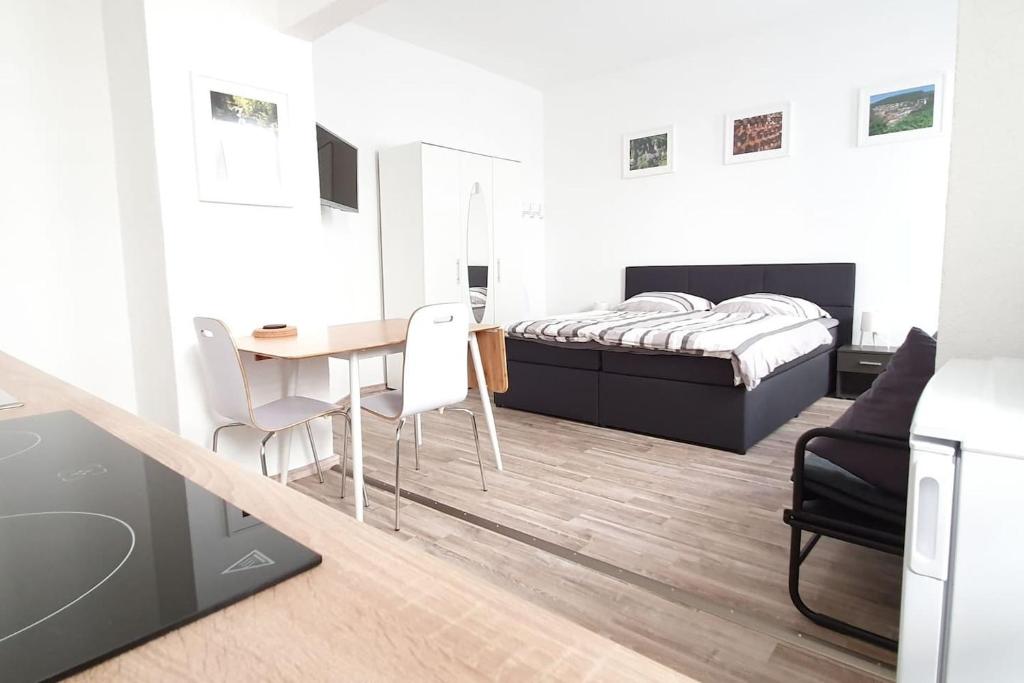 sypialnia z łóżkiem, stołem i krzesłami w obiekcie H-Apartment 2 w mieście Triberg