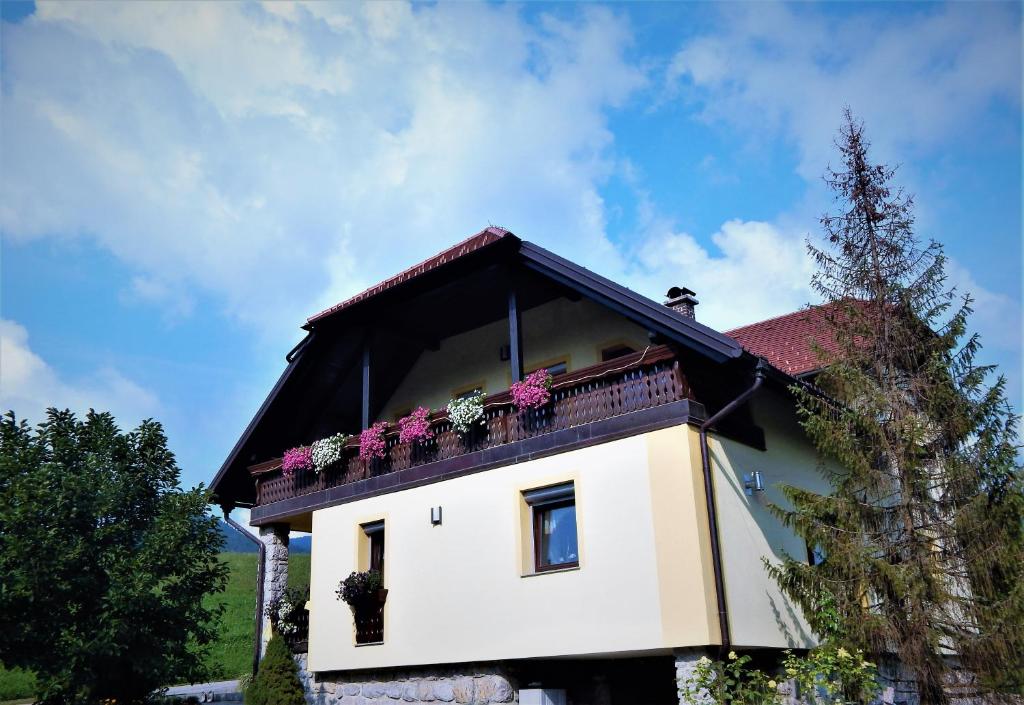uma casa com uma varanda com flores em Apartment Ana em Ljubno