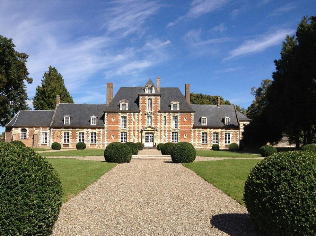 a large brick house with a black roof at Chateau de Vauchelles in Vauchelles-lès-Domart