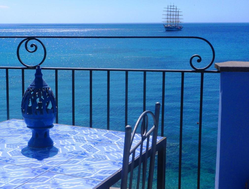 a blue vase sitting on a table next to the ocean at Hotel Palladio in Giardini Naxos