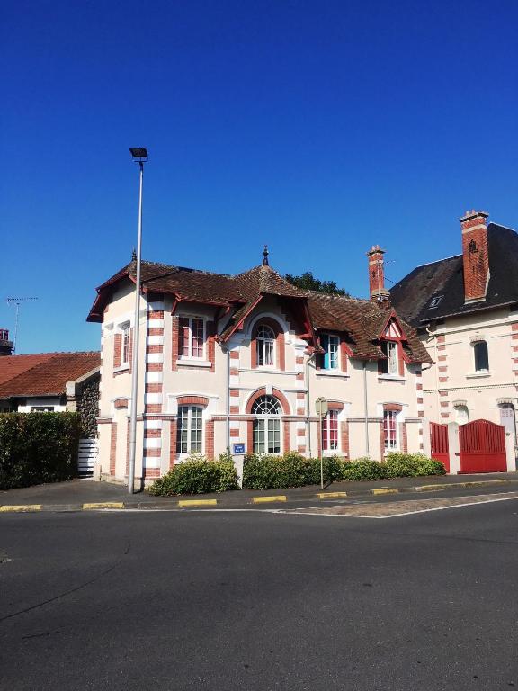 un grand bâtiment blanc avec un toit marron dans l'établissement kerwatt, à Cabourg