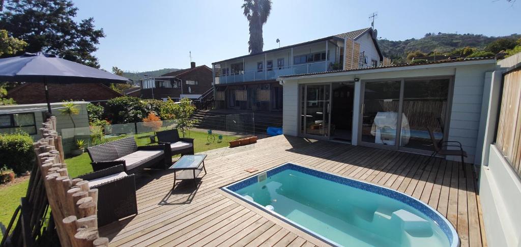 a deck with a swimming pool and a house at Knys-to-stay in Knysna