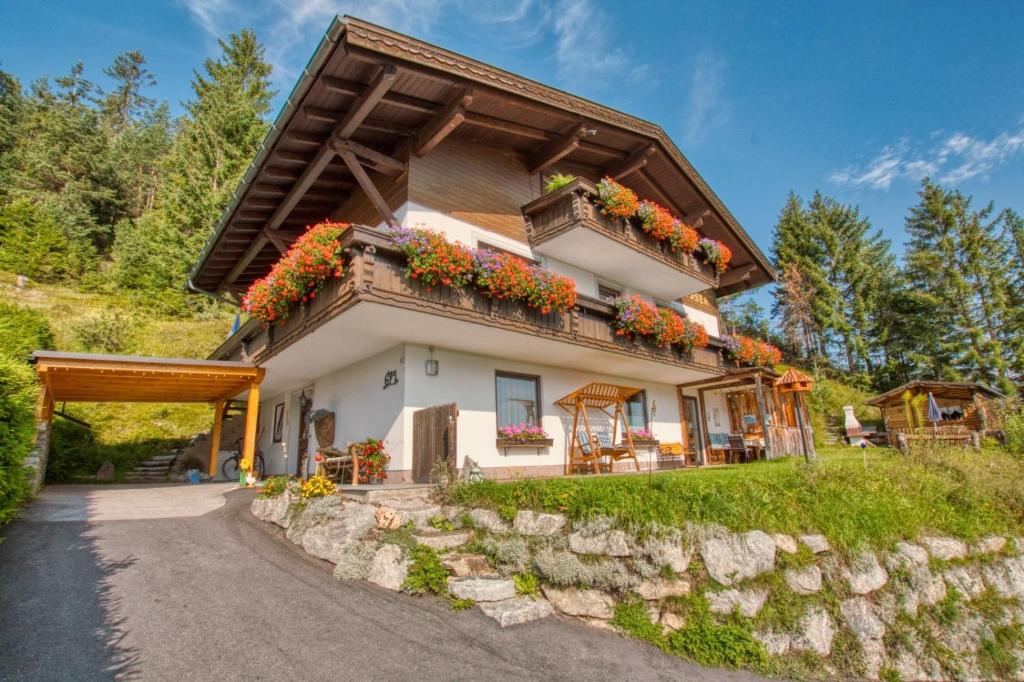Una casa en una colina con flores. en Panorama-Ferienwohnung Isser, en Seefeld in Tirol