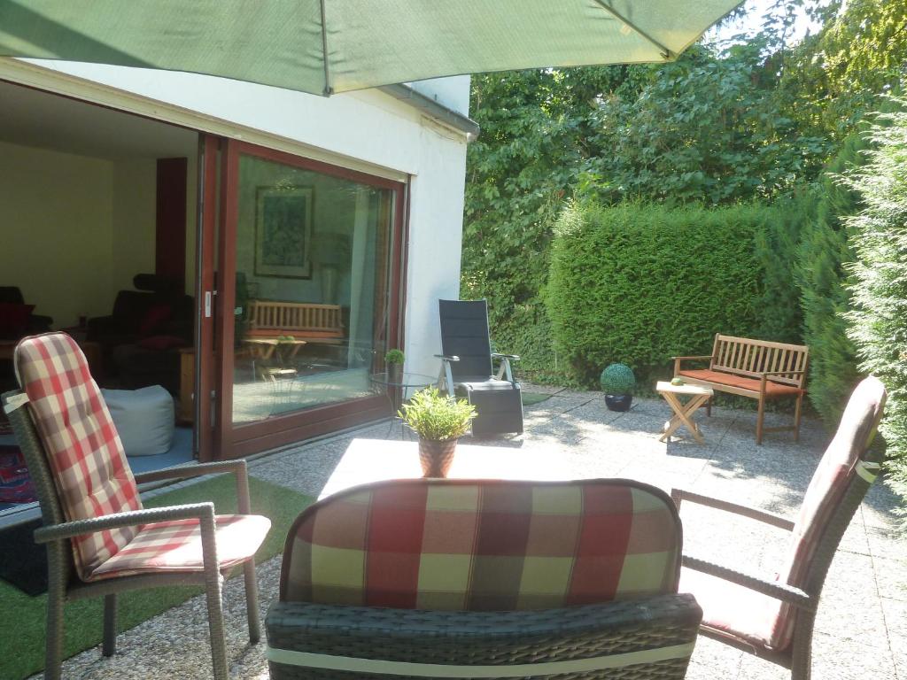 eine Terrasse mit Stühlen und einem Tisch mit einem Sonnenschirm in der Unterkunft Residenz Rosenstraße in Bad Harzburg