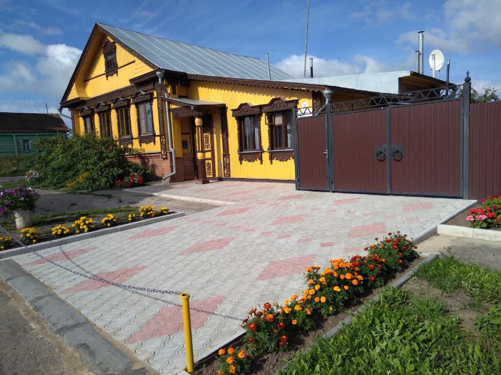 スーズダリにあるHouse near Monasteryの花の多い黄色い家