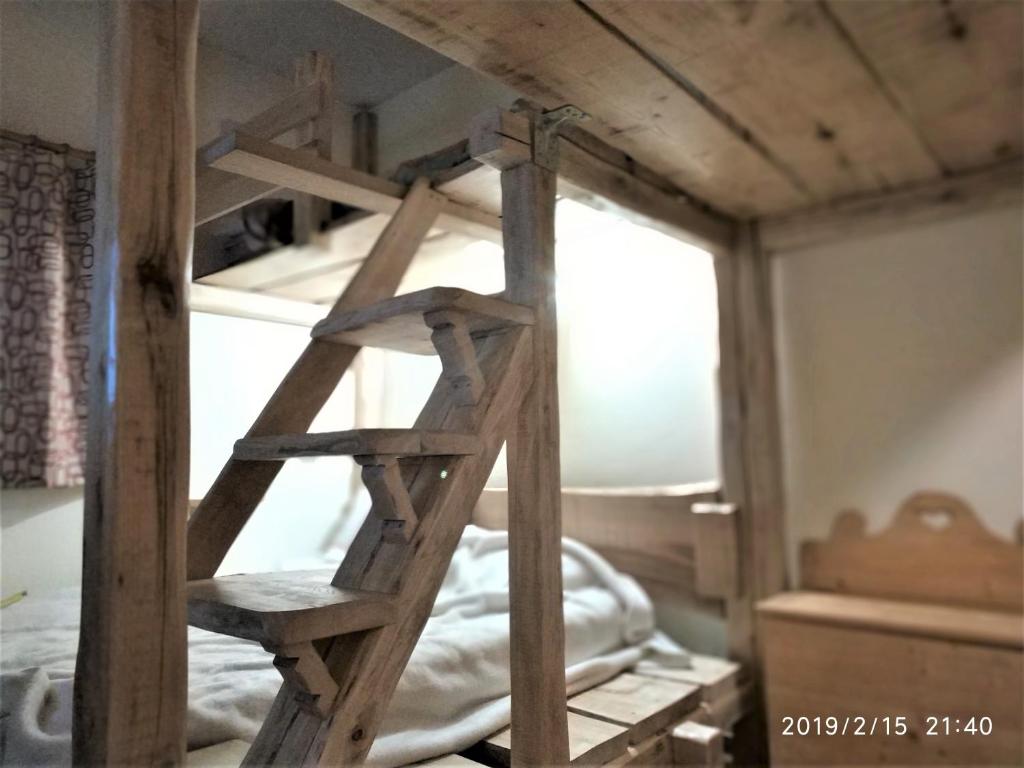 een houten ladder in een kamer met een stapelbed bij IL COVO DELLO SCIATORE in Falcade
