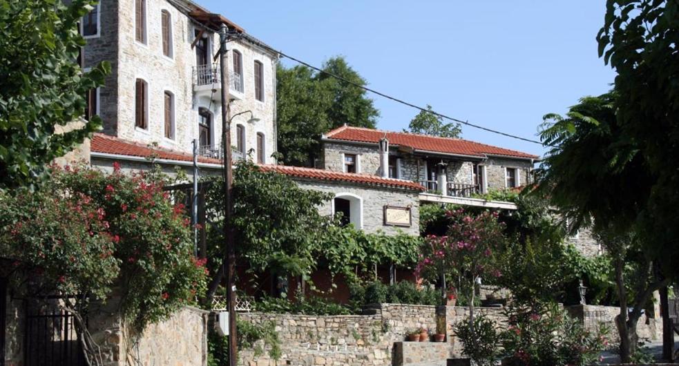 een groep gebouwen met bomen en een hek bij Guesthouse Parthenon in Parthenón