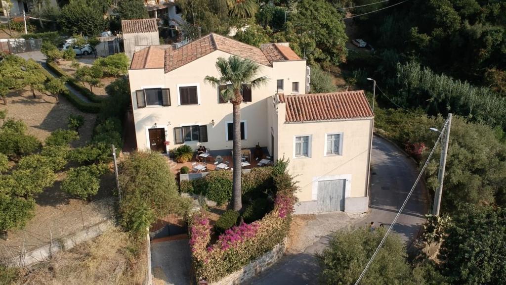 an aerial view of a white house with a palm tree at Bouganville B&B in Cefalù