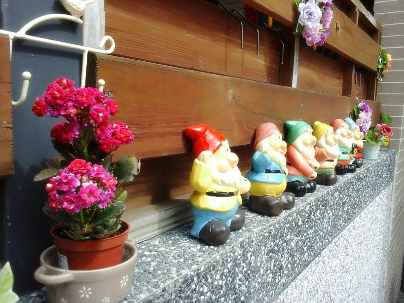a row of figurines sitting on a ledge next to flowers at Taitung Love Hostel in Taitung City