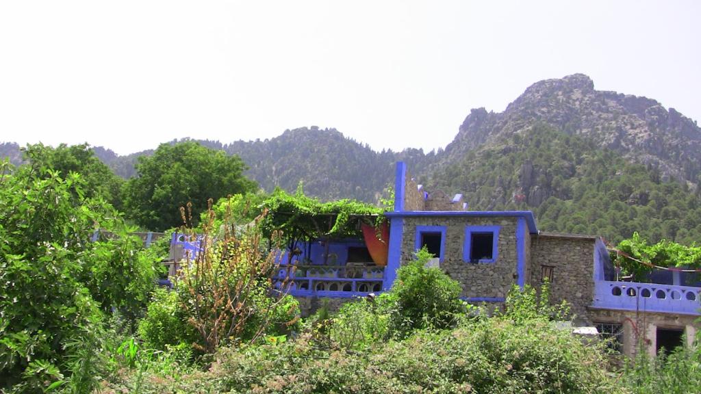 a blue house with a mountain in the background at Gîte de montagne Azilane in Izilane