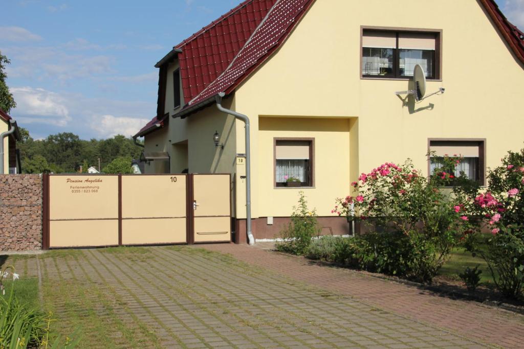 una casa con una valla y una entrada de ladrillo en Pension Angelika, en Cottbus