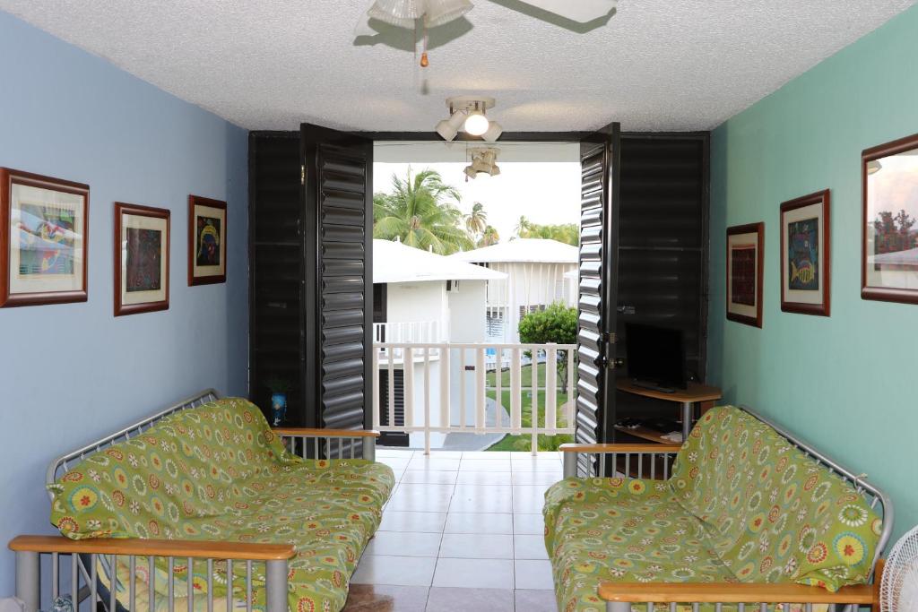 a living room with two chairs and a television at Caguax 206 in Cabo Rojo