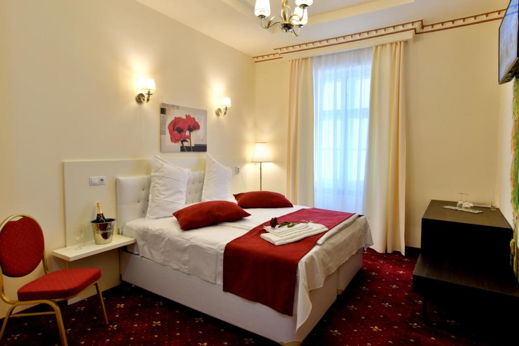 Habitación de hotel con cama con manta roja en Top Royal Central Brasov en Brasov