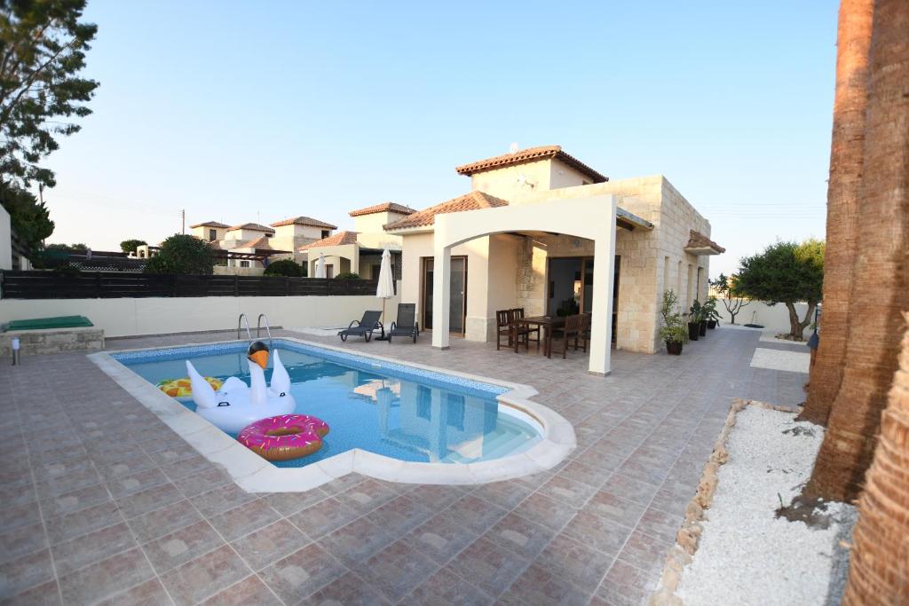 a swimming pool in front of a house at Villa Trachonas in Pissouri