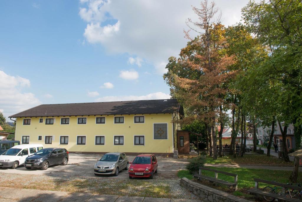 a building with cars parked in a parking lot at Hostel M in Maribor