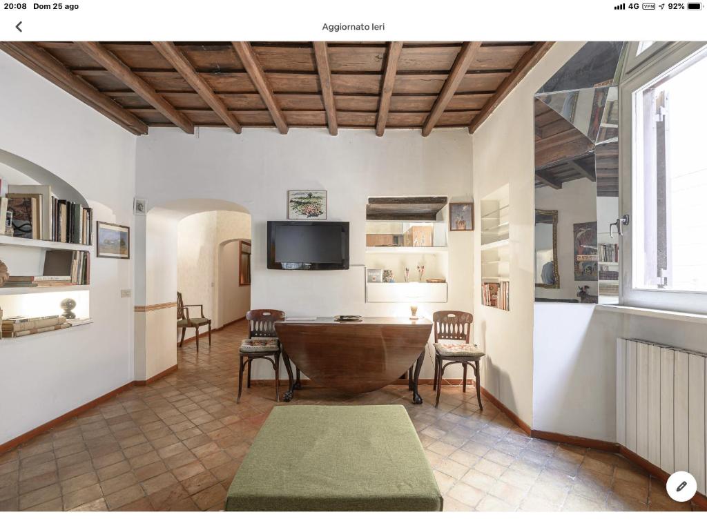 un soggiorno con tavolo, sedie e TV di The cozy nest a Roma