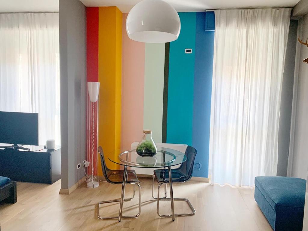 Pokój ze szklanym stołem i kolorową ścianą w obiekcie Smart House Bologna Centro w Bolonii