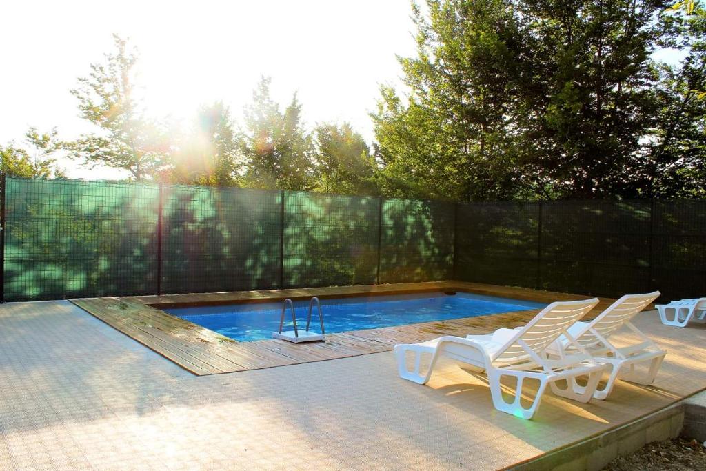 a swimming pool with two chairs and a swing at Vikendica Mušić in Prijedor