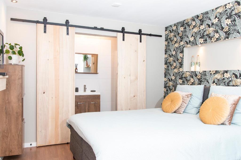 1 dormitorio con 1 cama blanca grande con almohadas amarillas en Eindhoven Inn en Eindhoven