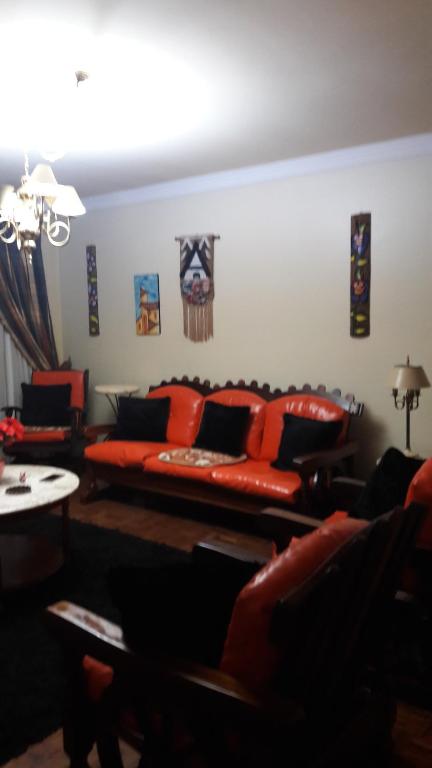 - un salon avec un canapé rouge et une table dans l'établissement apto centro de gramado, à Gramado