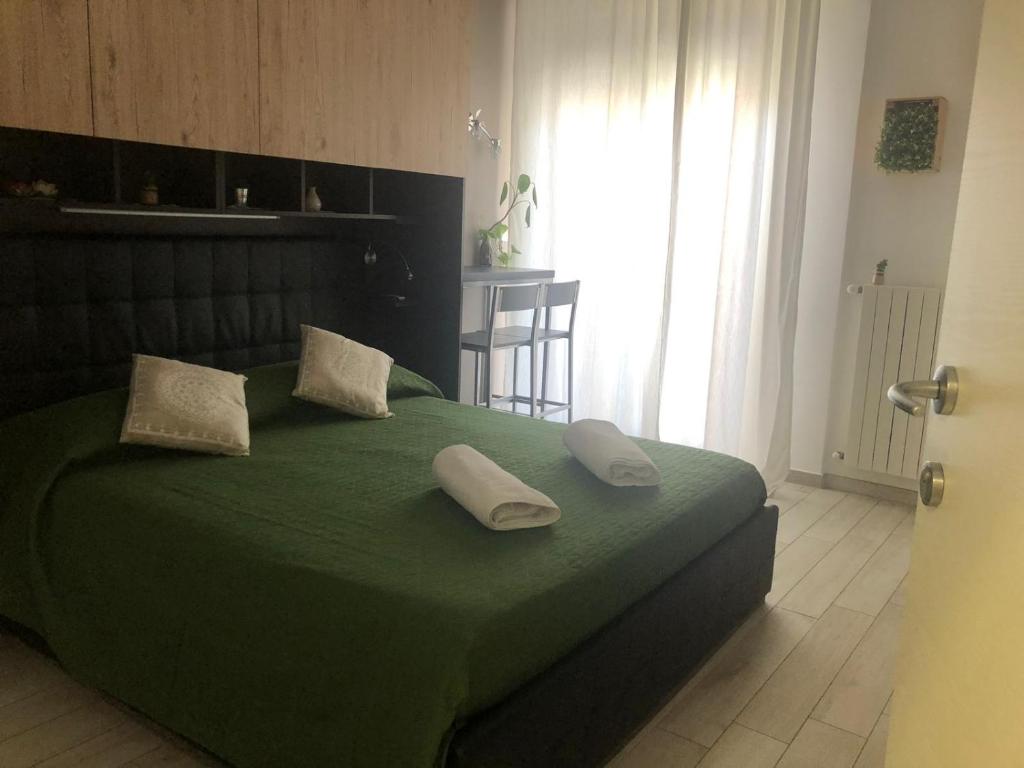 um quarto com uma cama verde com duas almofadas em B&B Calypso em Pescara