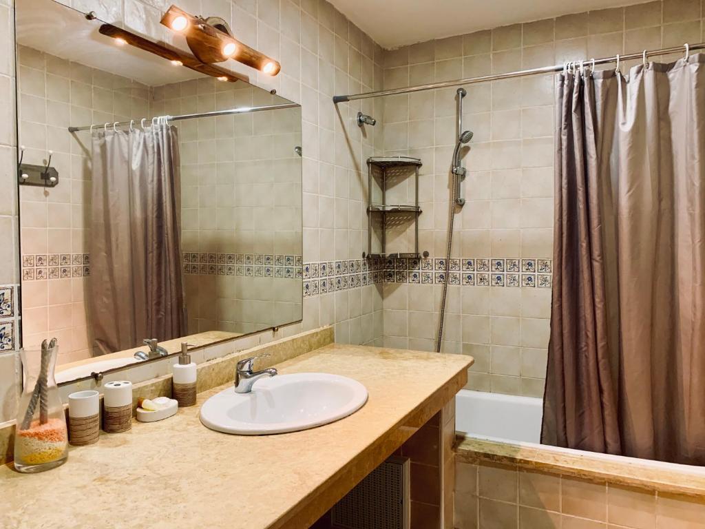 a bathroom with a sink and a shower and a tub at Marina Saidia AP8 LILIA in Saïdia