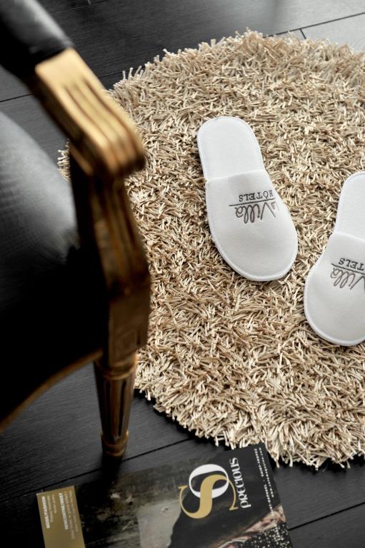 a pair of white flip flops sitting on a rug at Hôtel La Villa Cannes in Cannes