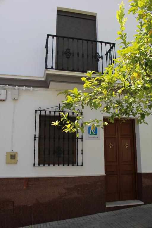 ein Gebäude mit einem Balkon und einer Tür in der Unterkunft Casa Manolito in Prado del Rey
