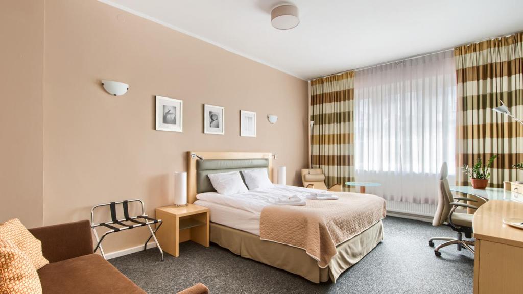 Habitación de hotel con cama y escritorio en 404 Rooms Wilanowska, en Varsovia