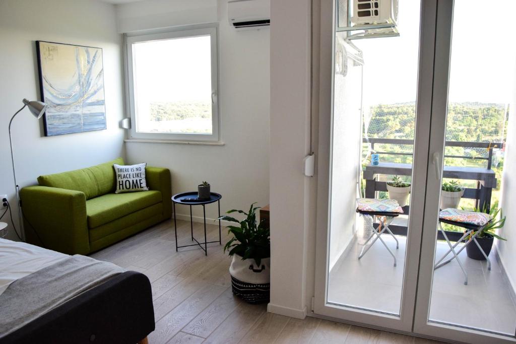 a bedroom with a green couch and a balcony at sky in Pula